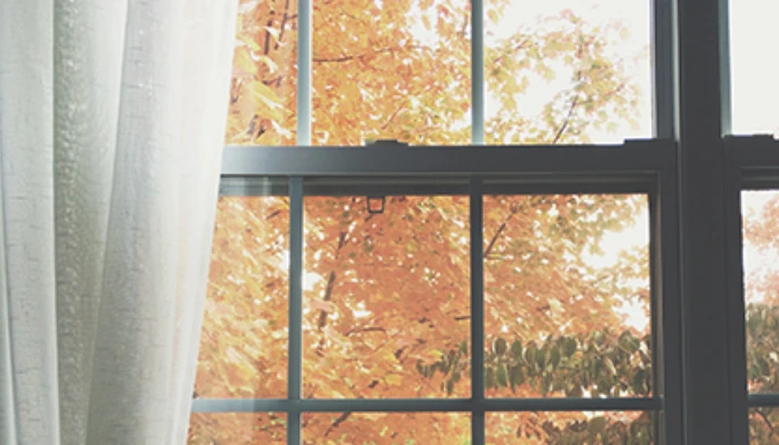 Moderne Vorhänge am Fenster im Wohnraum, dekorativer Sicht- und Sonnenschutz nach Maß