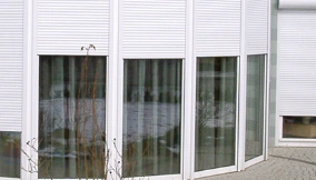 Geschlossene Rollläden an Fenstern eines Wohnhauses, Sicht- und Wärmeschutz für mehr Energieeffizienz